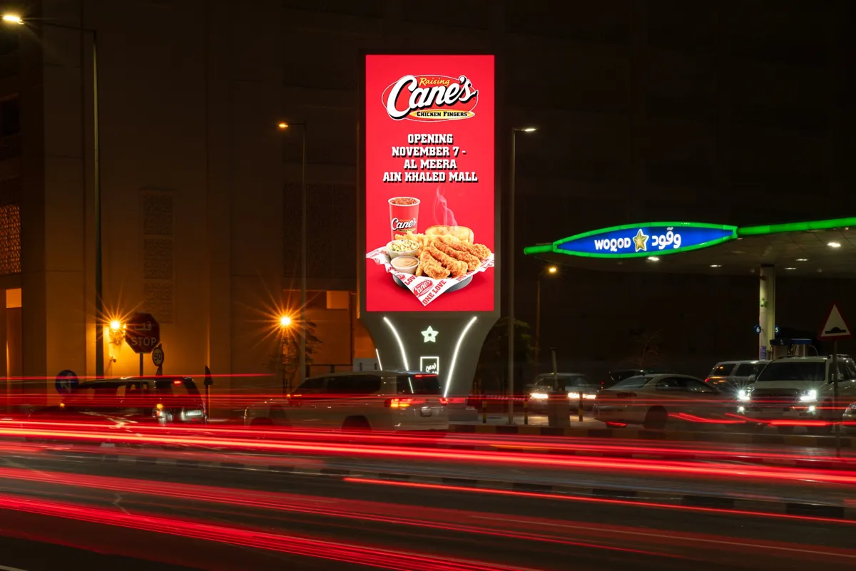 Portrait ELAN DOOH tower beside a Woqod station