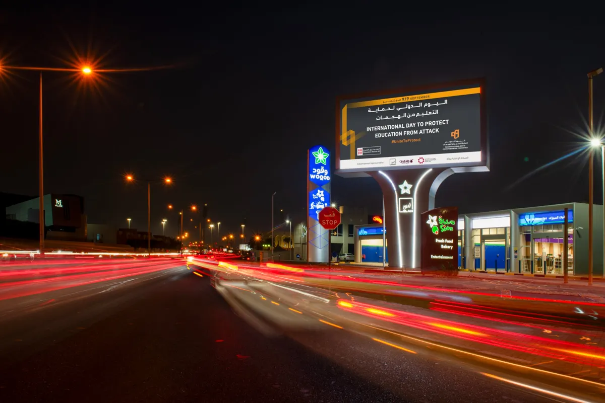 ELAN roadside DOOH pylon at a Woqod station at night